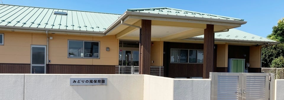みどりの農場保育園の施設外観。ベージュと茶色を基調とした平屋建ての建物。